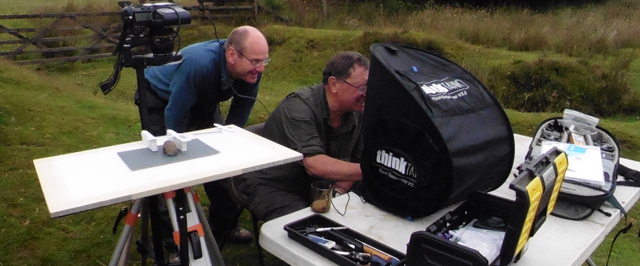 Volunteers photographing a stone macehead fragment in the field