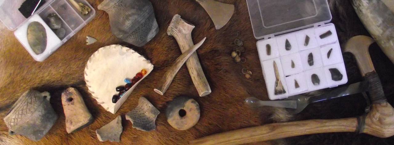 Reconstruction Mesolithic and Bronze Age items displayed on a deer skin